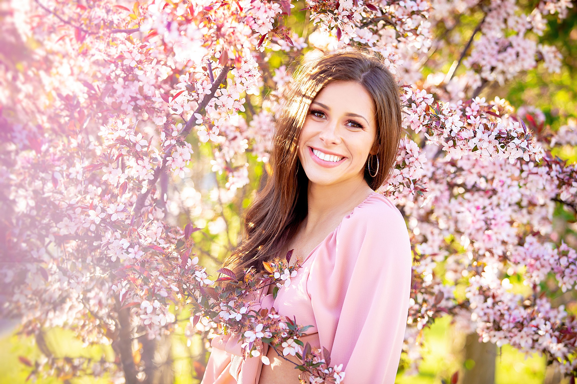 senior portrait of girl around pink flowers