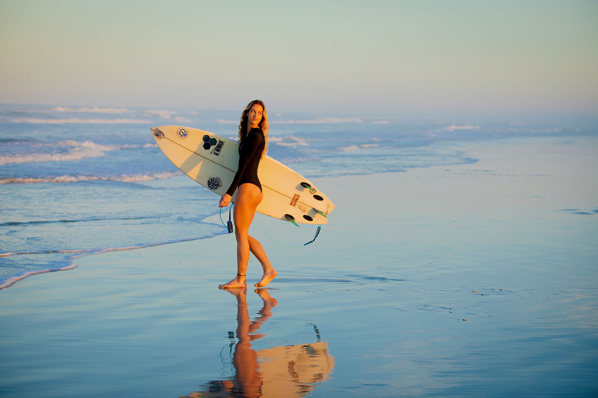destination portrait photographer captures woman with surfboard 