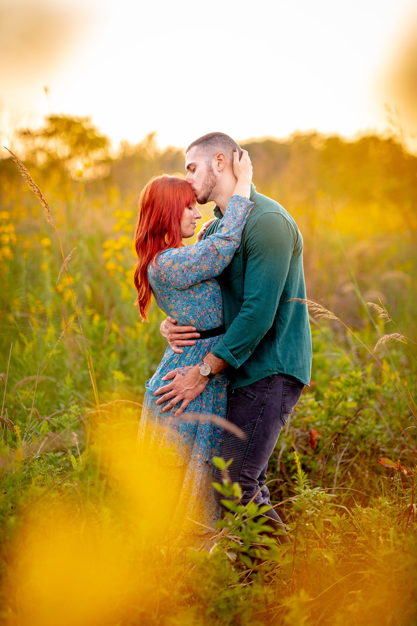 couple embrace in field of tall grass captured by light and airy photographer 
