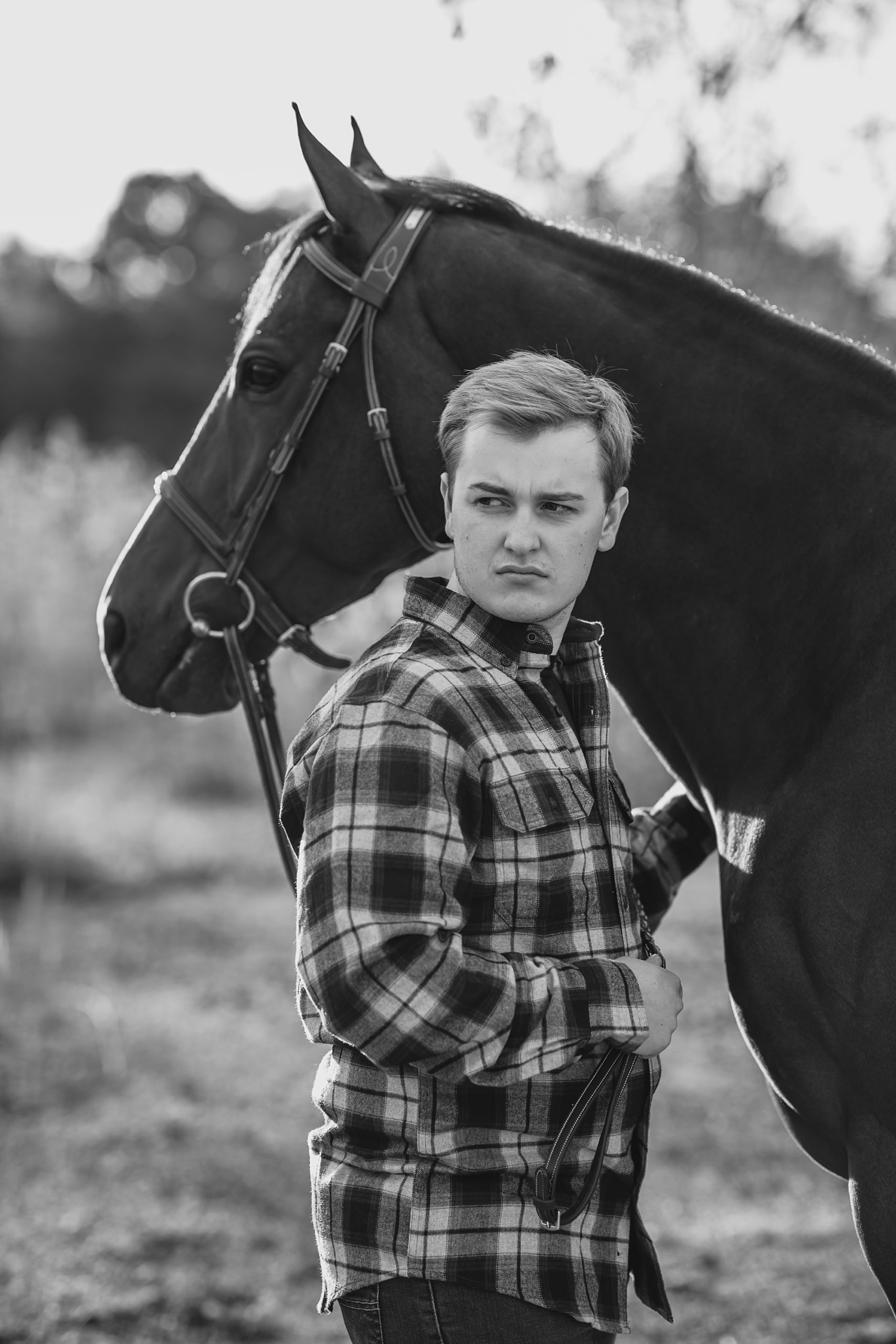 black and white photo of man next tot his horse